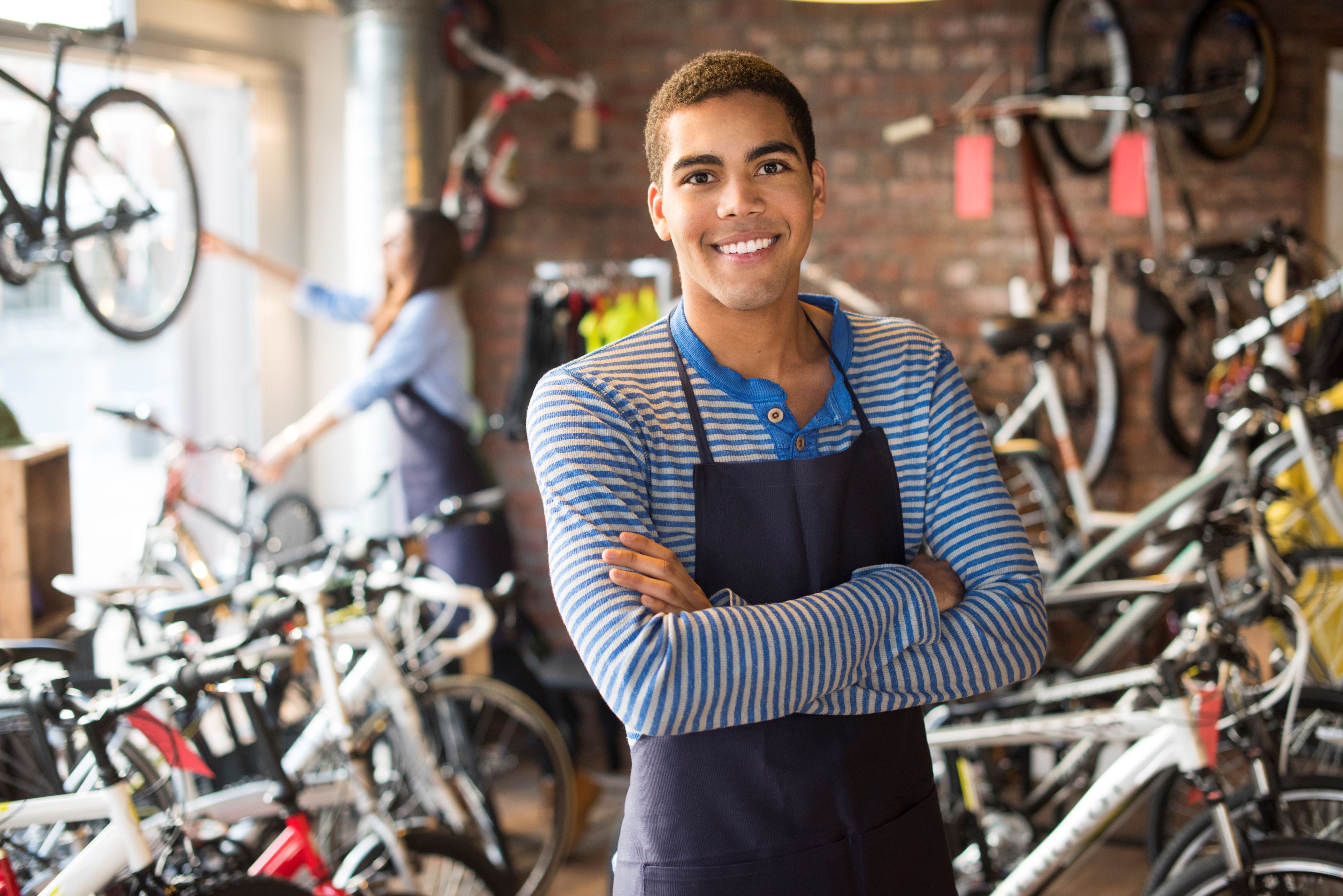 Retail bike shop clerk posing proudly in store