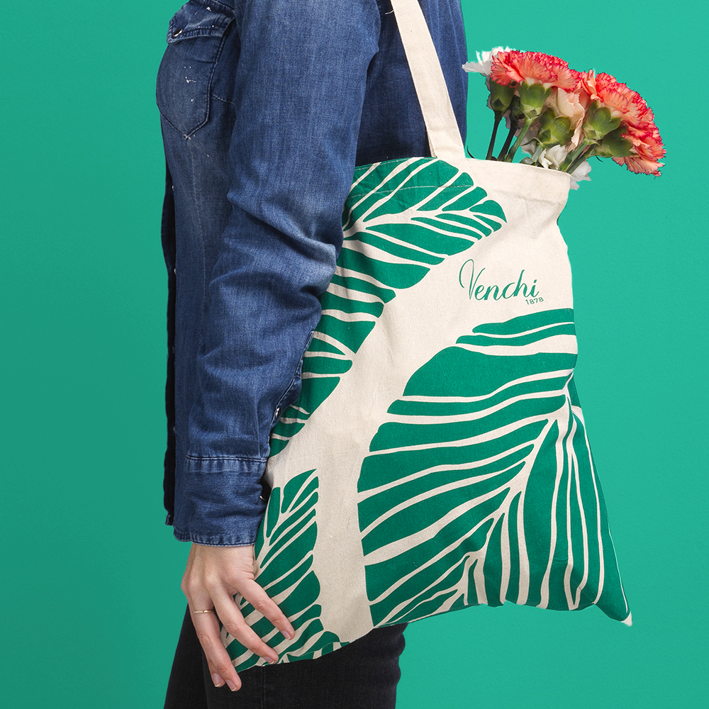 Tote bag in cotone con design floreale verde su sfondo bianco