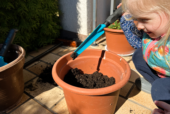girl-holding-tool-potted-plant