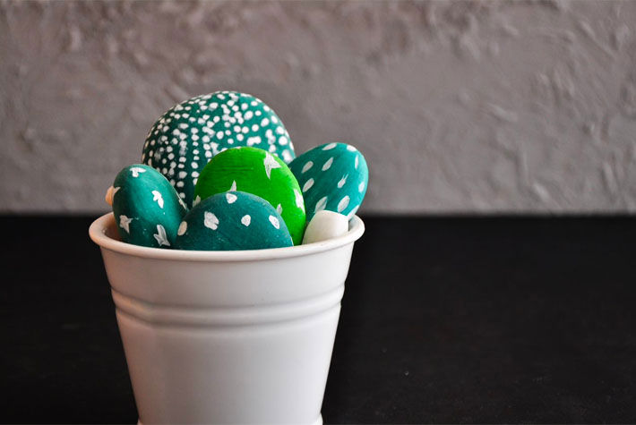 painted green pebbles in a white pot