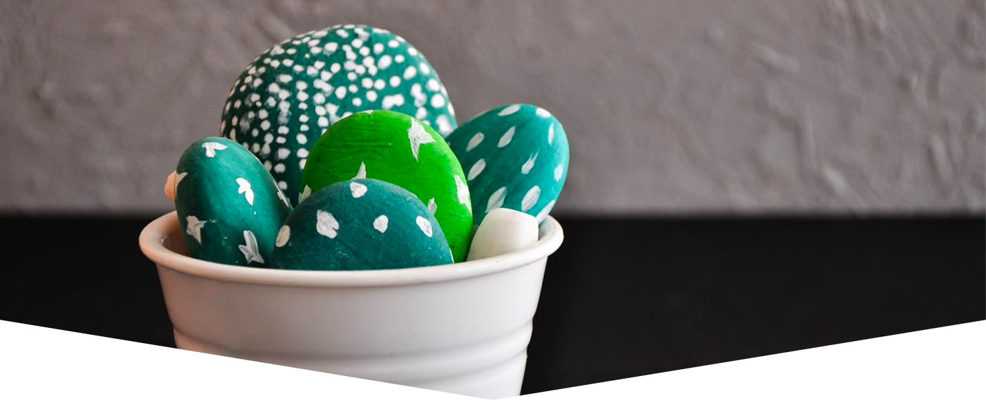 painted green pebbles in a white pot